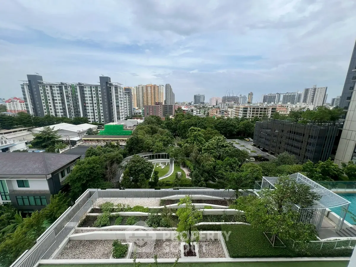 Stunning cityscape view from a high-rise balcony overlooking lush greenery and urban skyline.