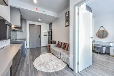 Modern open-plan living room with stylish decor and sleek kitchen in a contemporary apartment.