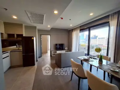 Modern open-plan living room with city view, stylish dining area, and sleek kitchen in urban apartment.