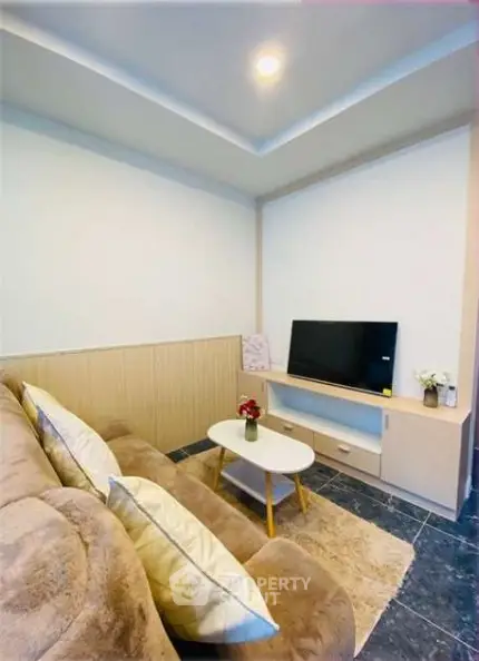 Cozy living room with plush sofa and modern TV setup, perfect for relaxation.