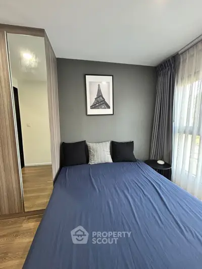 Modern bedroom with stylish decor and large window for natural light