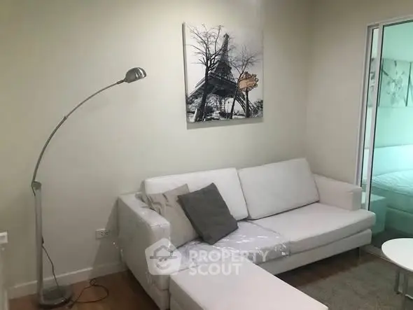 Modern living room with white sofa and stylish floor lamp, perfect for cozy relaxation.