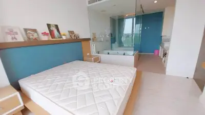 Spacious bedroom with modern design and glass-enclosed bathtub offering a luxurious living experience.