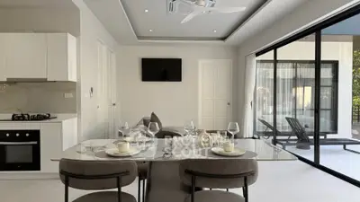 Modern open-plan living room with elegant dining area and large sliding glass doors to patio.