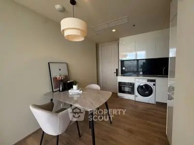 Modern kitchen with dining area, featuring sleek appliances and stylish decor.