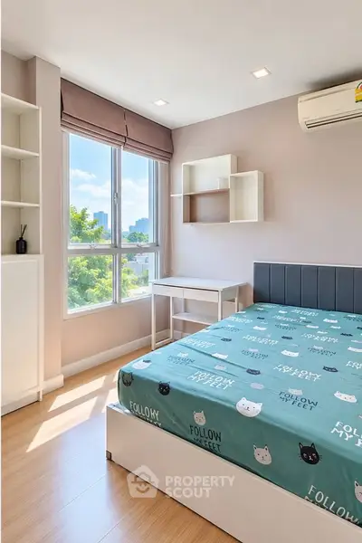 Bright bedroom with large window and modern furnishings in a stylish apartment.