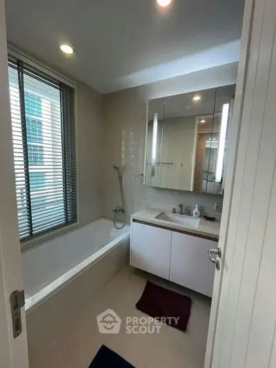 Modern bathroom with sleek design, featuring a bathtub and large mirror, perfect for relaxation and comfort.