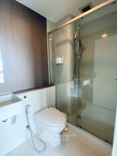 Modern bathroom with glass shower and sleek fixtures in a contemporary apartment.