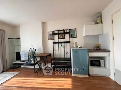 Charming living space with modern decor and compact kitchen area, perfect for urban living.