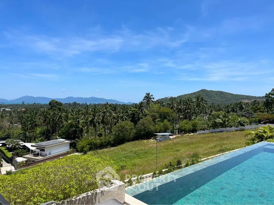 Stunning infinity pool with panoramic mountain and lush greenery views in tropical paradise.