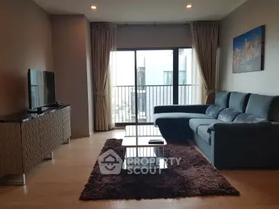 Spacious living room with modern furniture and large window balcony view.