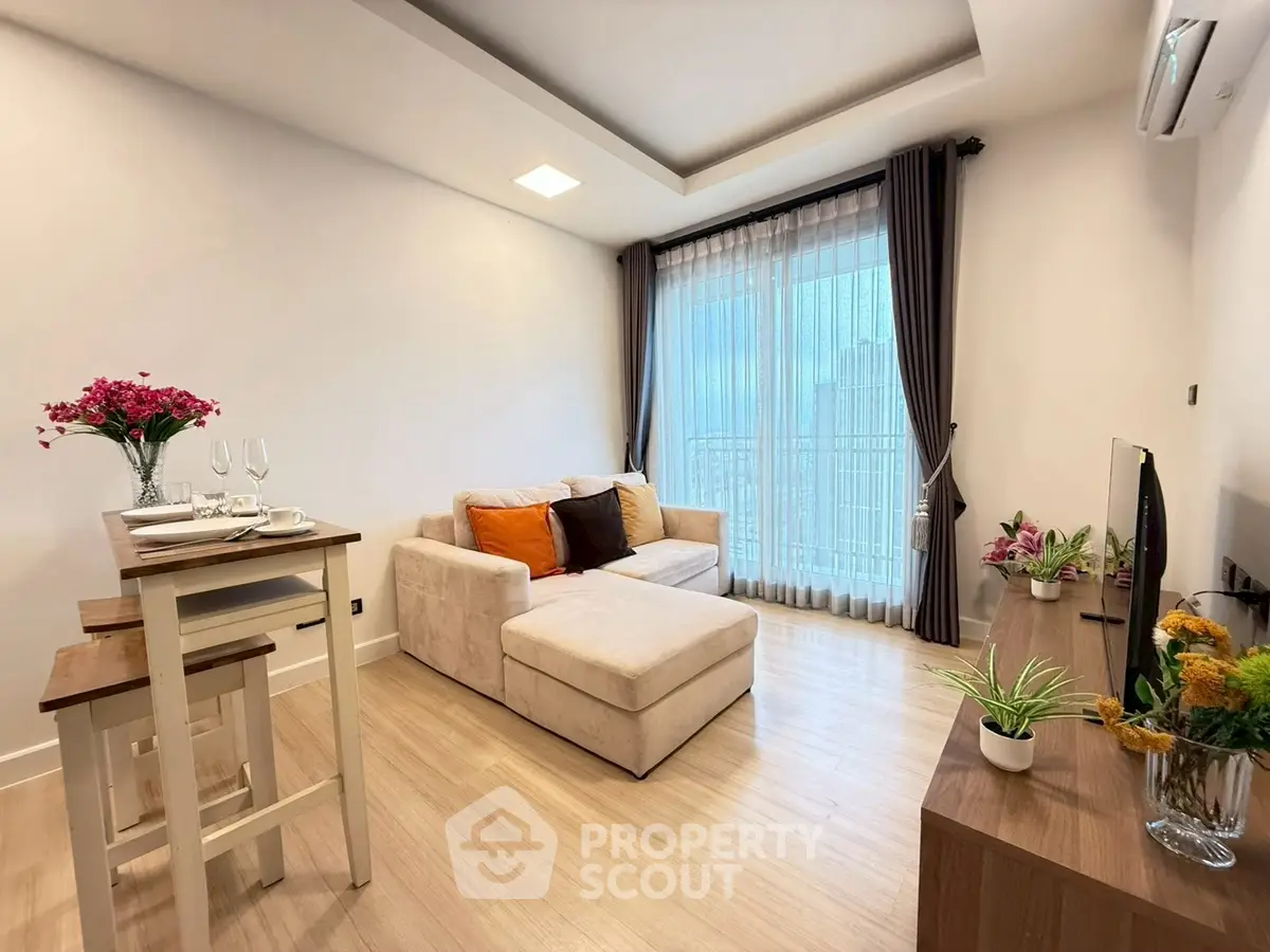 Modern living room with cozy sofa and dining area, featuring elegant decor and large window with city view.