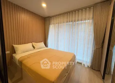 Cozy bedroom with modern decor and large window with sheer curtains