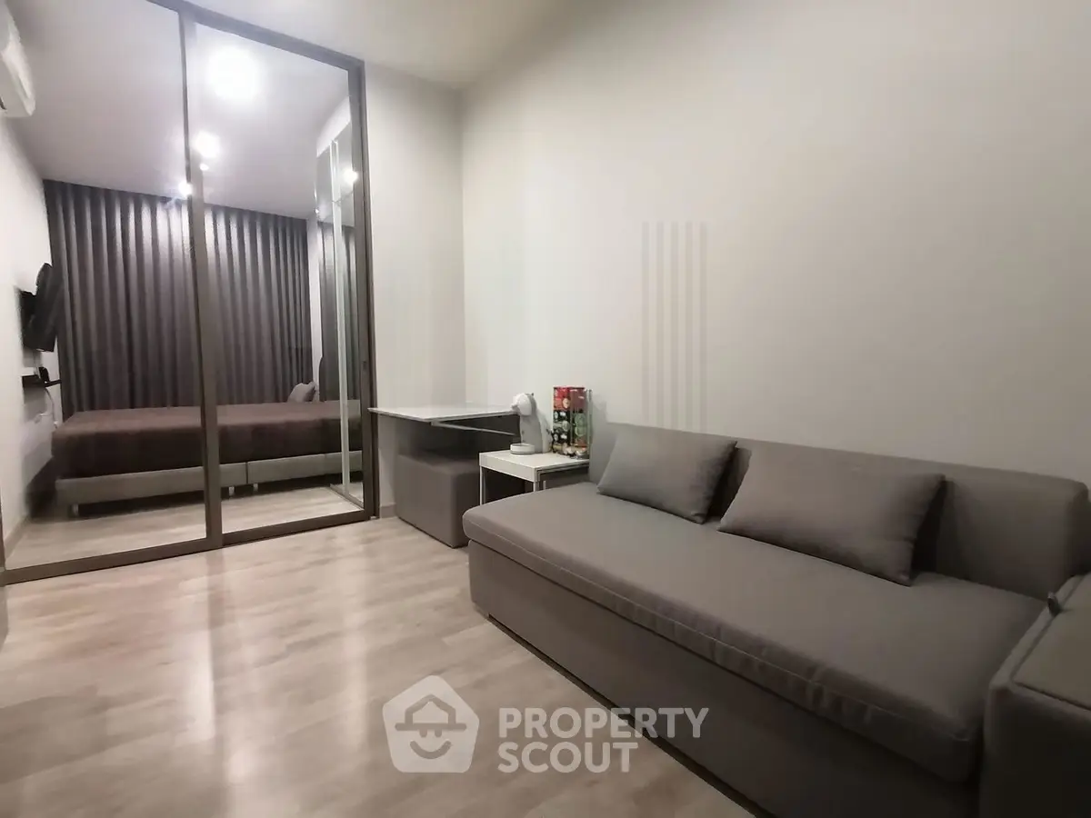 Modern living room with sleek sofa and mirrored closet in stylish apartment