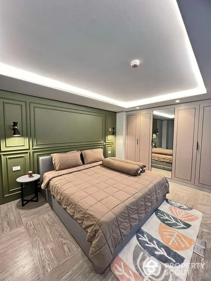 Modern bedroom with stylish green accent wall and cozy bedding