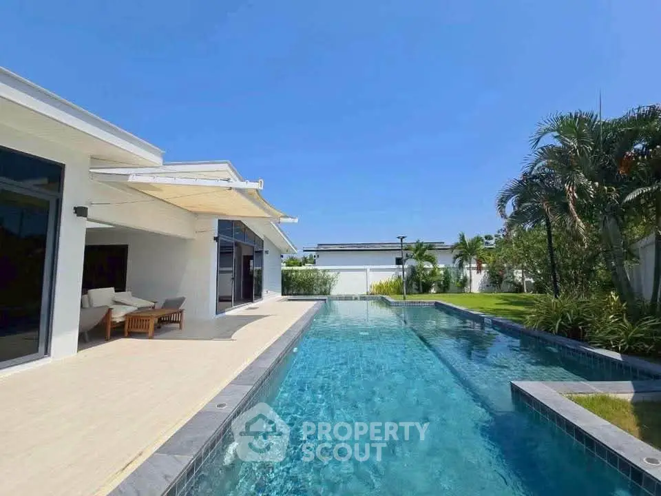 Luxurious modern home with stunning pool and lush garden view