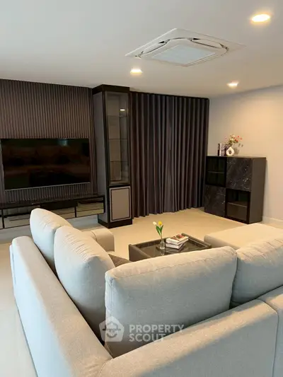 Modern living room with sleek furniture and large TV, perfect for relaxation and entertainment.