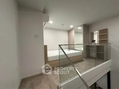 Modern bedroom with glass railing and wooden flooring