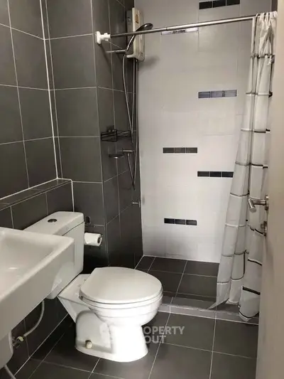 Modern bathroom with sleek gray tiles and compact shower area