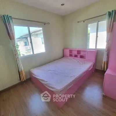 Charming bedroom with pink furniture and large windows for natural light