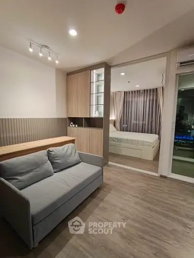 Modern studio apartment with cozy living area and stylish bedroom, featuring elegant wood flooring and ambient lighting.