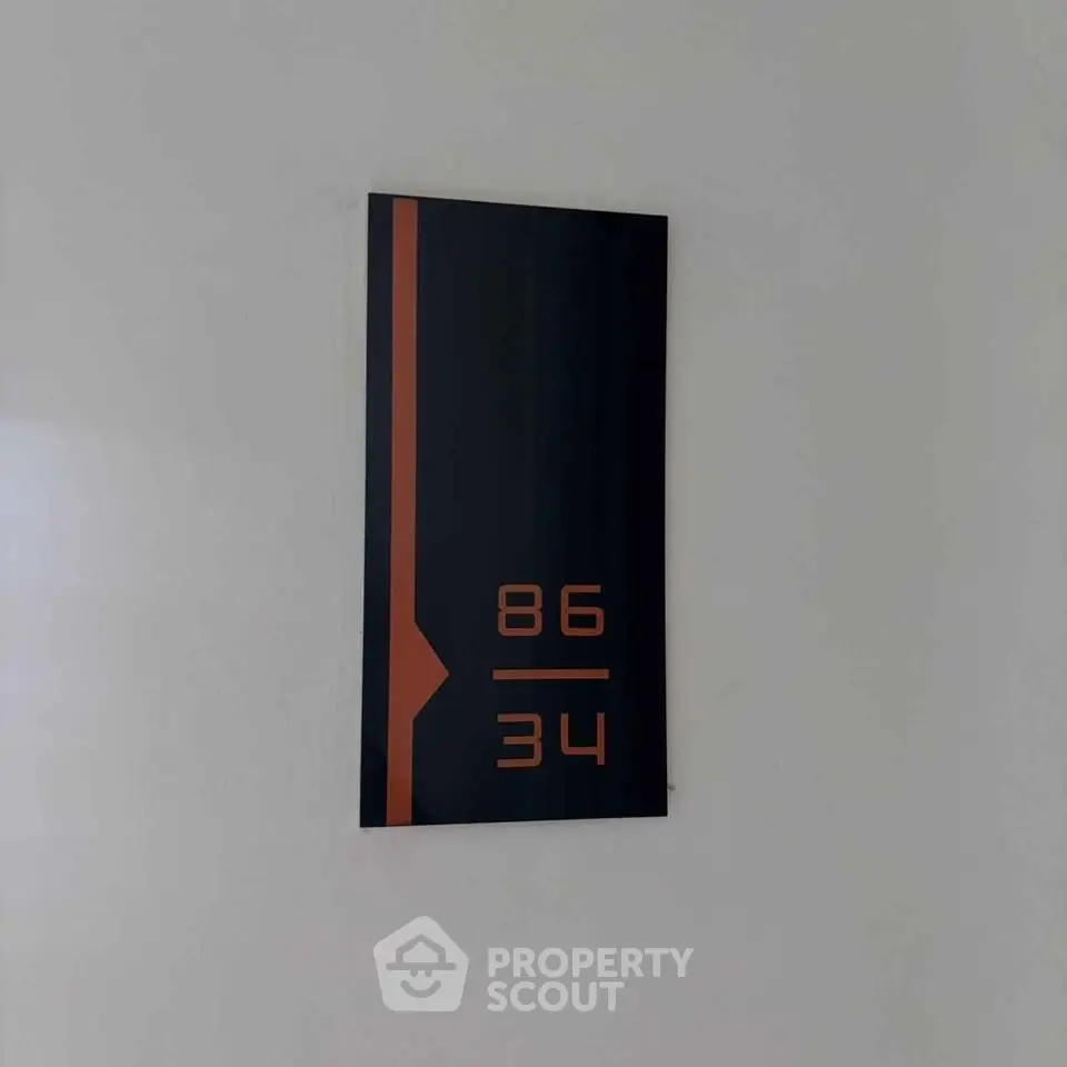 Modern apartment number sign on a sleek wall, enhancing property aesthetics.