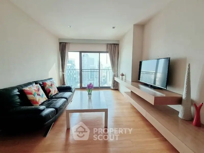 Modern living room with city view, sleek furniture, and natural light.