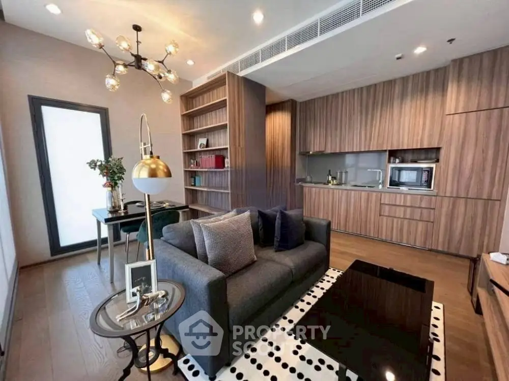 Modern living room with open kitchen, stylish lighting, and cozy seating area.