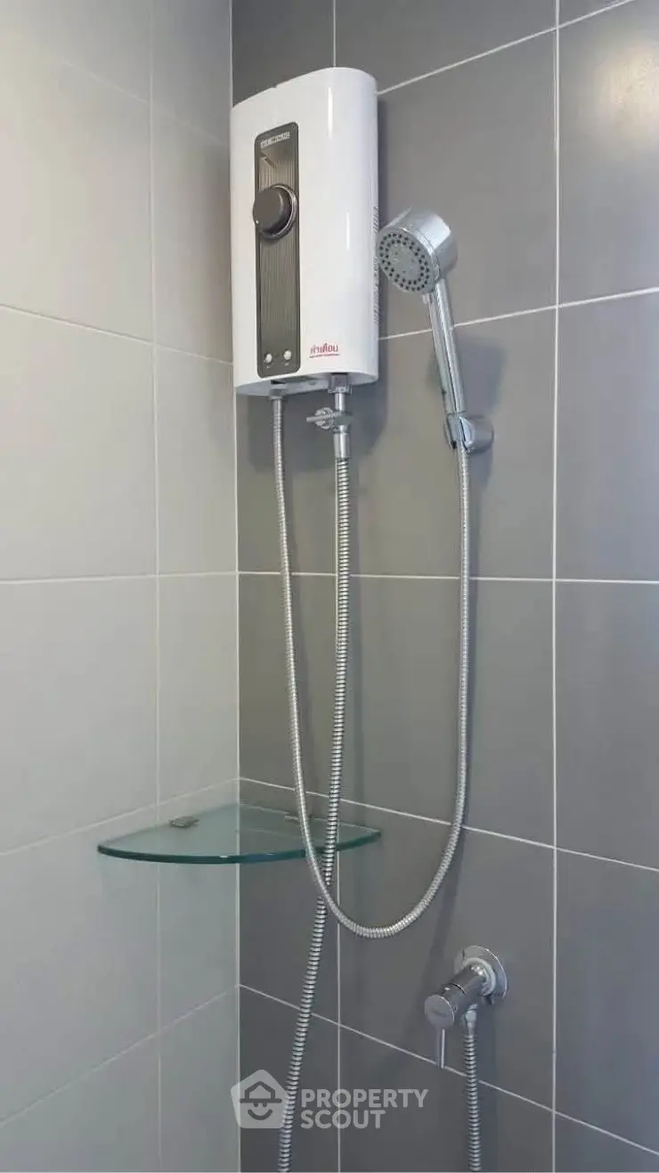 Modern bathroom with sleek shower unit and glass shelf, perfect for contemporary living.