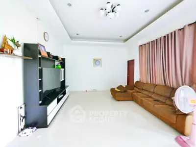 Spacious living room with modern entertainment center and cozy brown sofa