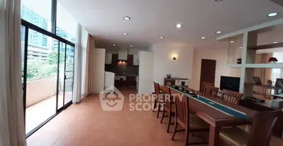 Spacious open-plan living and dining area with large windows and balcony access in modern apartment.