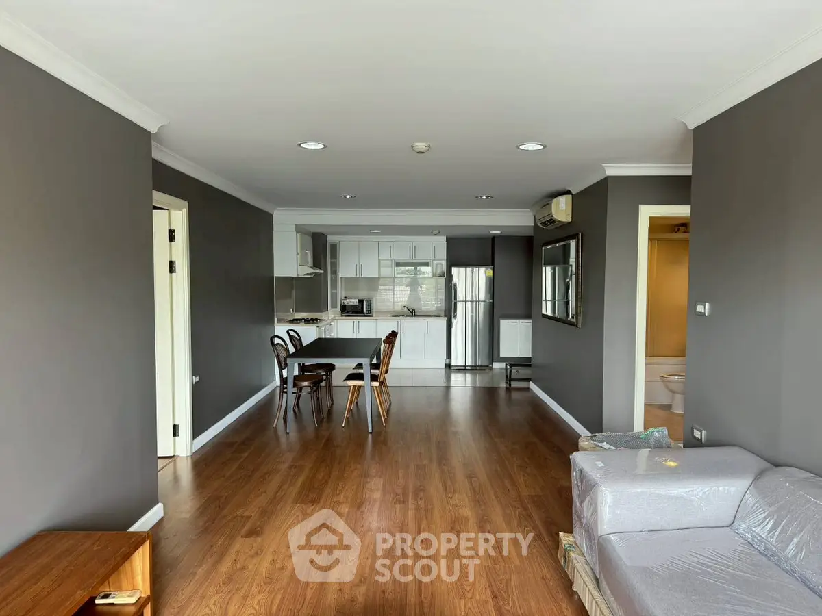 Spacious open-plan living room with modern kitchen and wooden flooring