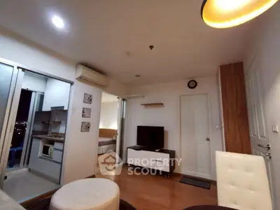 Modern apartment interior with open layout, featuring cozy living room and adjacent kitchen area.