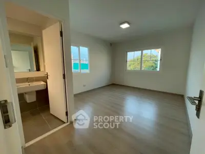 Spacious empty bedroom with en-suite bathroom and large windows