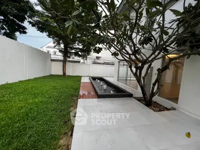 Modern backyard with lush lawn and sleek water feature in a contemporary home setting.