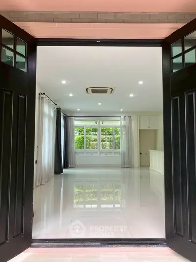 Spacious modern living room with large windows and glossy floor
