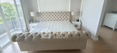 Luxurious bedroom with elegant tufted bed and balcony access