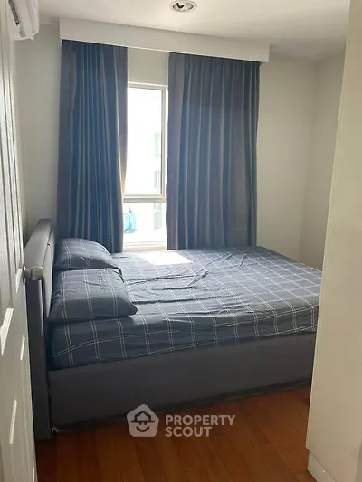 Cozy bedroom with large window and stylish curtains, perfect for natural light lovers.