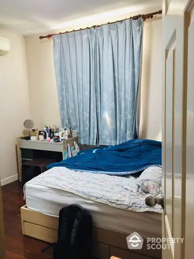 Cozy bedroom with ample natural light, featuring a comfortable bed, elegant curtains, and a practical study area, perfect for relaxation and productivity.