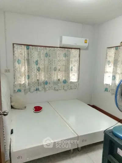 Cozy bedroom with air conditioning and simple decor, perfect for a comfortable stay.