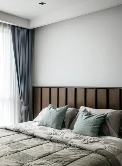 Elegant bedroom with modern decor and natural light from large window.