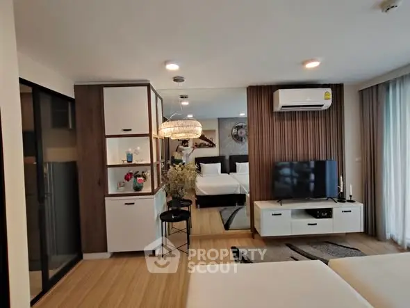 Modern living room with stylish decor and open layout, featuring a cozy seating area and entertainment center.