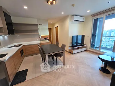 Modern open-plan living room with kitchen and balcony view in a stylish apartment.