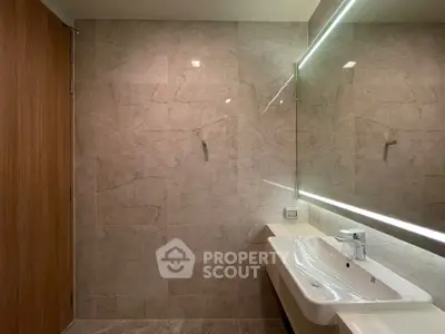 Modern bathroom with elegant marble tiles and sleek sink design.