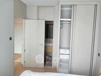 Modern bedroom with built-in closet and ensuite bathroom in a stylish apartment.