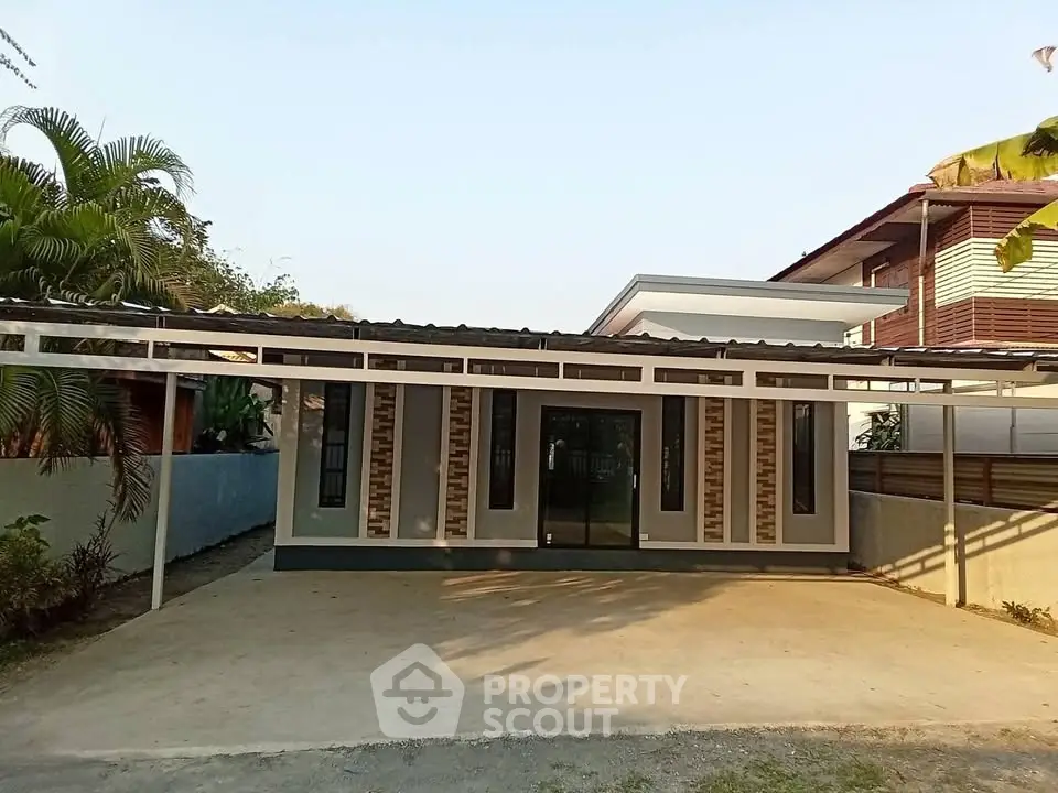 Modern single-story house with spacious driveway and contemporary design.