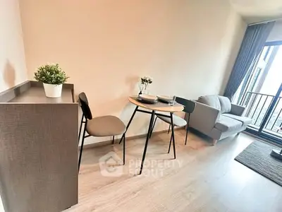 Modern living room with cozy seating and dining area, featuring a small balcony with natural light.