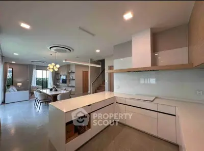 Modern open-layout kitchen with sleek design and spacious living area, perfect for contemporary living.