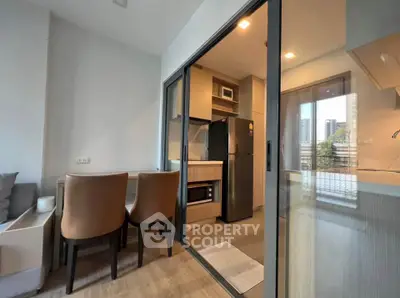 Modern apartment with open kitchen and dining area featuring sleek design and natural light.