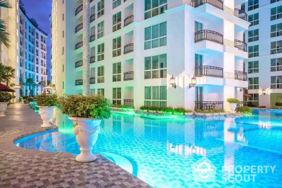 Luxurious apartment complex with stunning illuminated pool and elegant architecture.